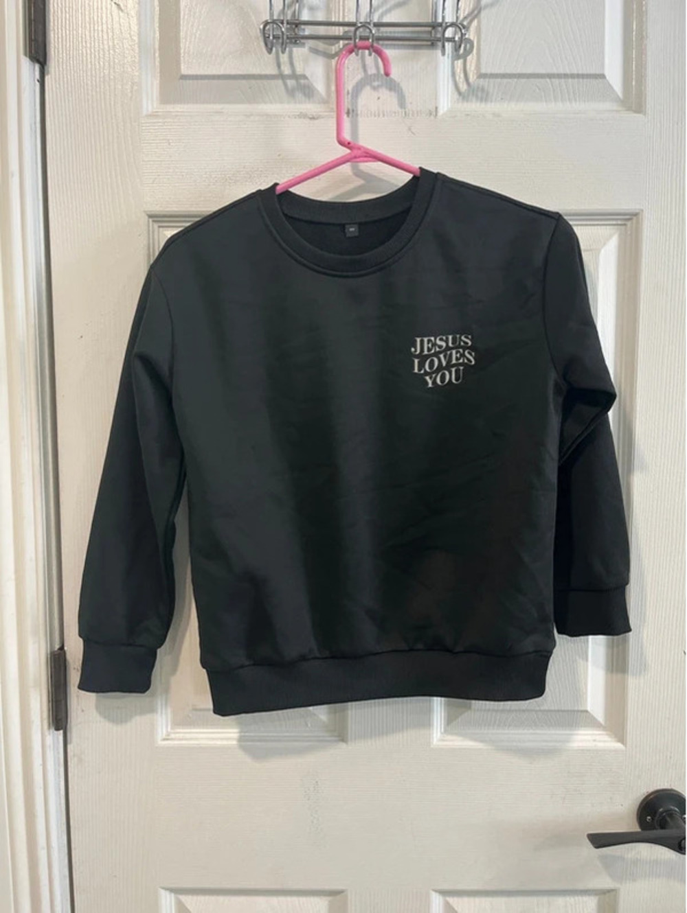 Girls size 11 black crewneck sweatshirt features "Jesus Loves You"